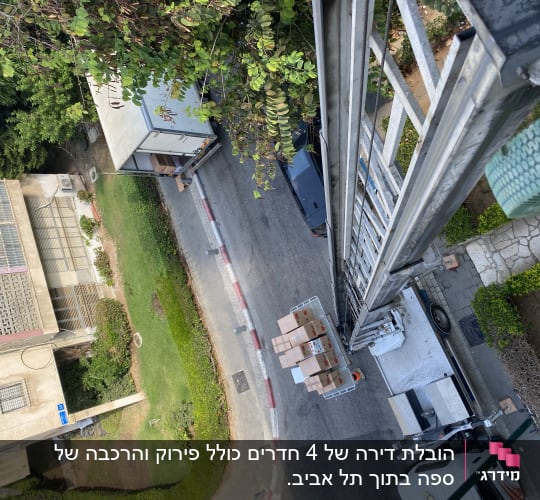 מנוף מעביר קרטונים למשאית ברחוב